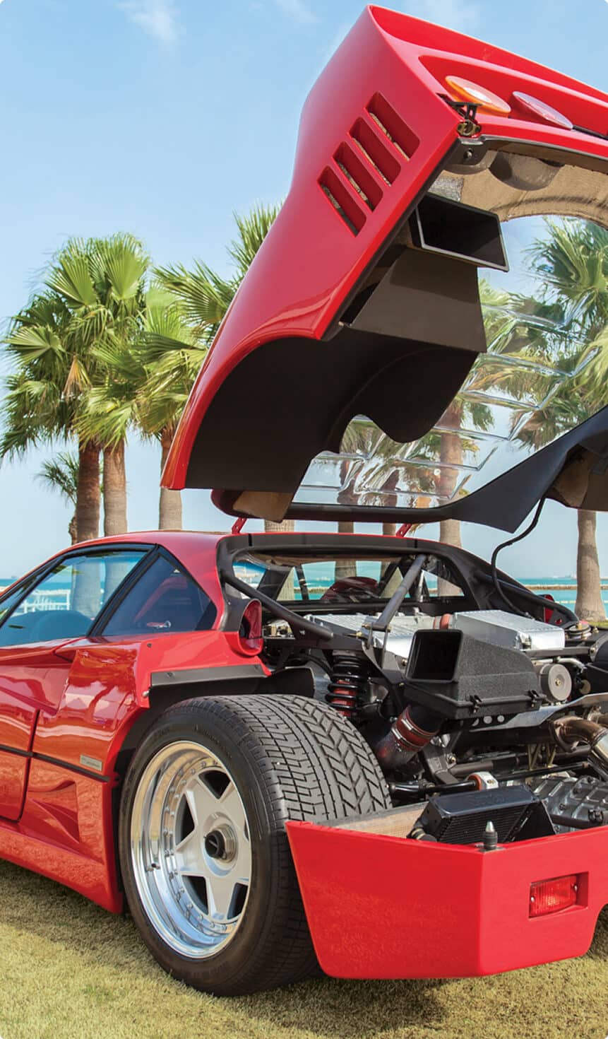 A red sports car with the hood raised, exposing the engine compartment and highlighting its sporty features