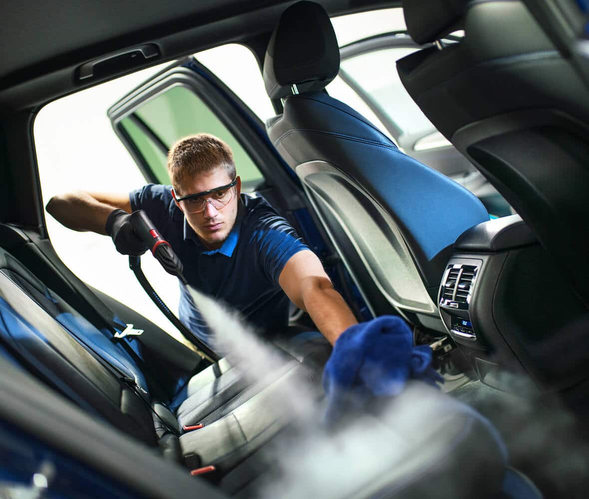 A man details the inside of a car