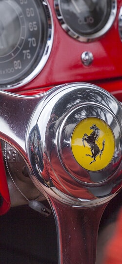 The steering wheel of a classic red Ferrari